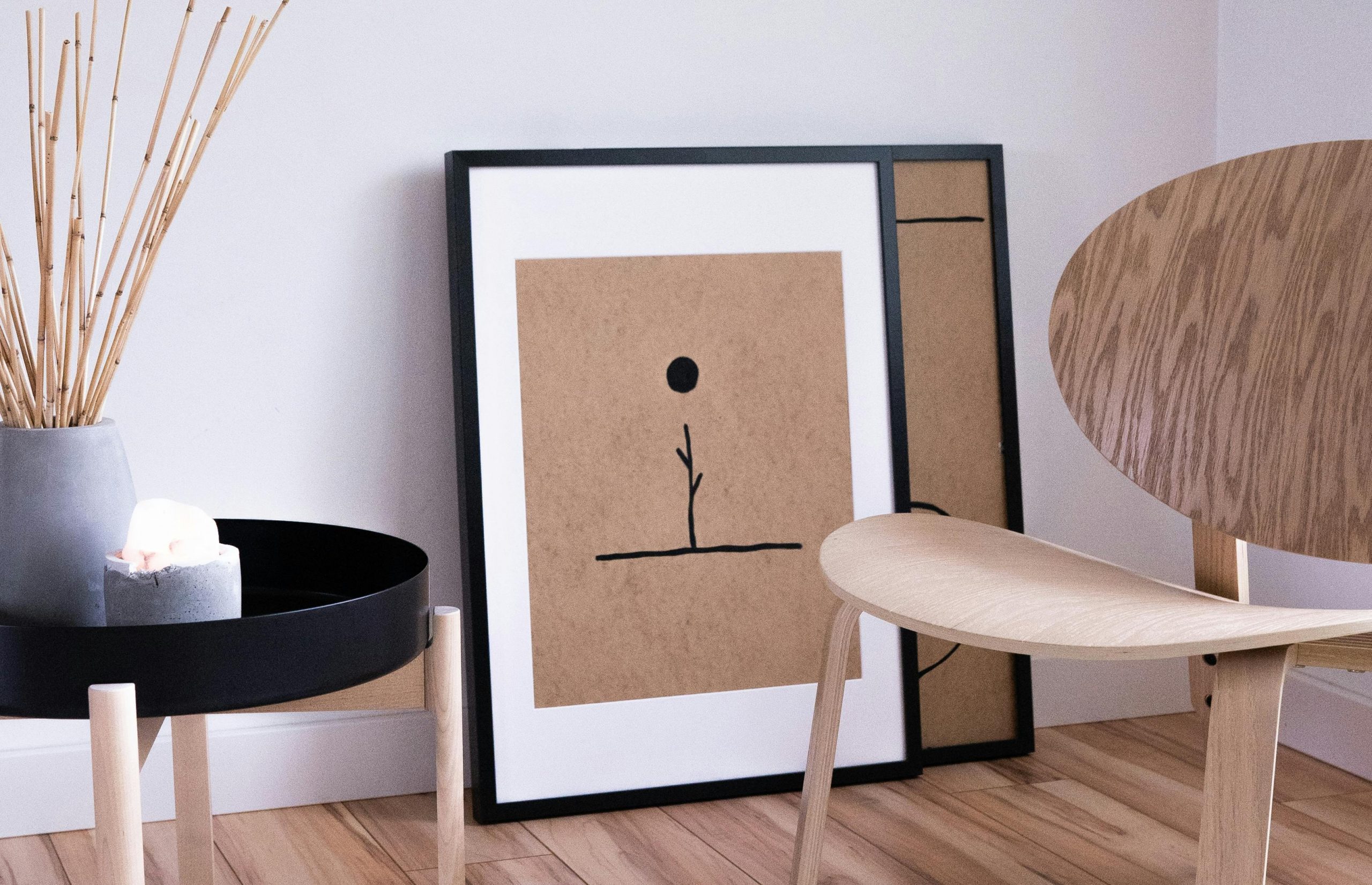 A serene Japandi style room with minimalist wooden furniture and abstract art on display.